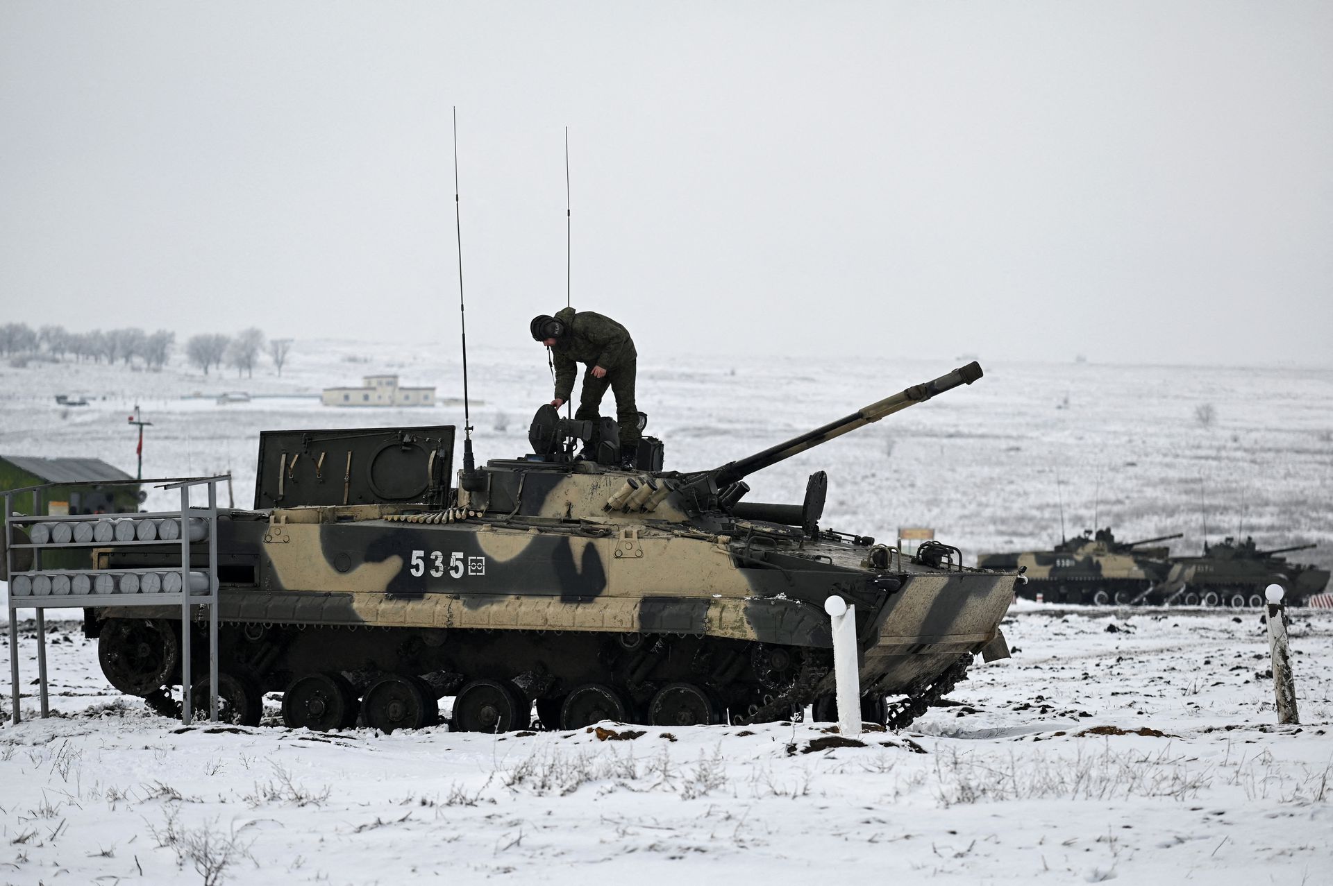 A Russian service member stands on a BMP-3