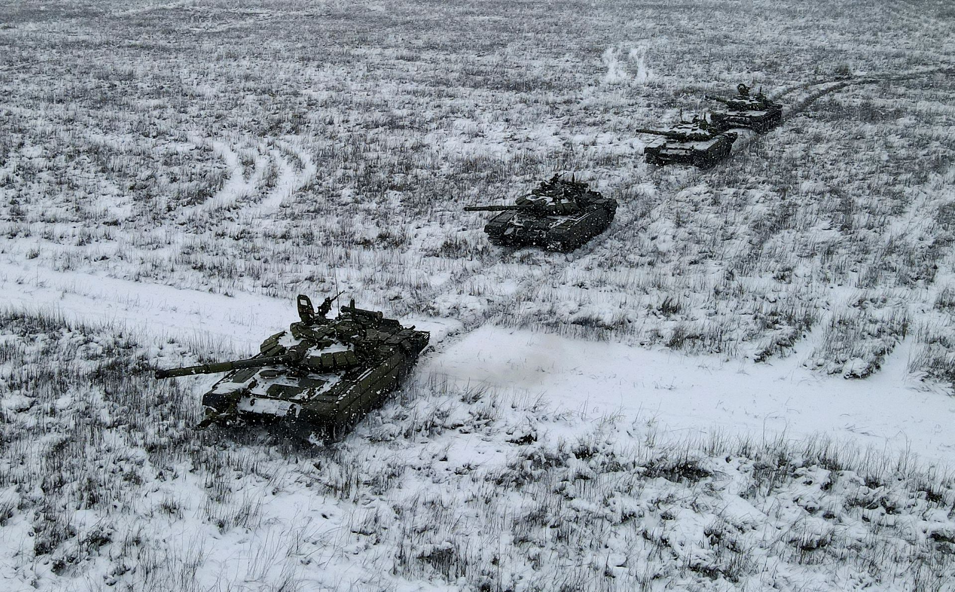 Russian T-72B3 main battle tanks drive during snowfall